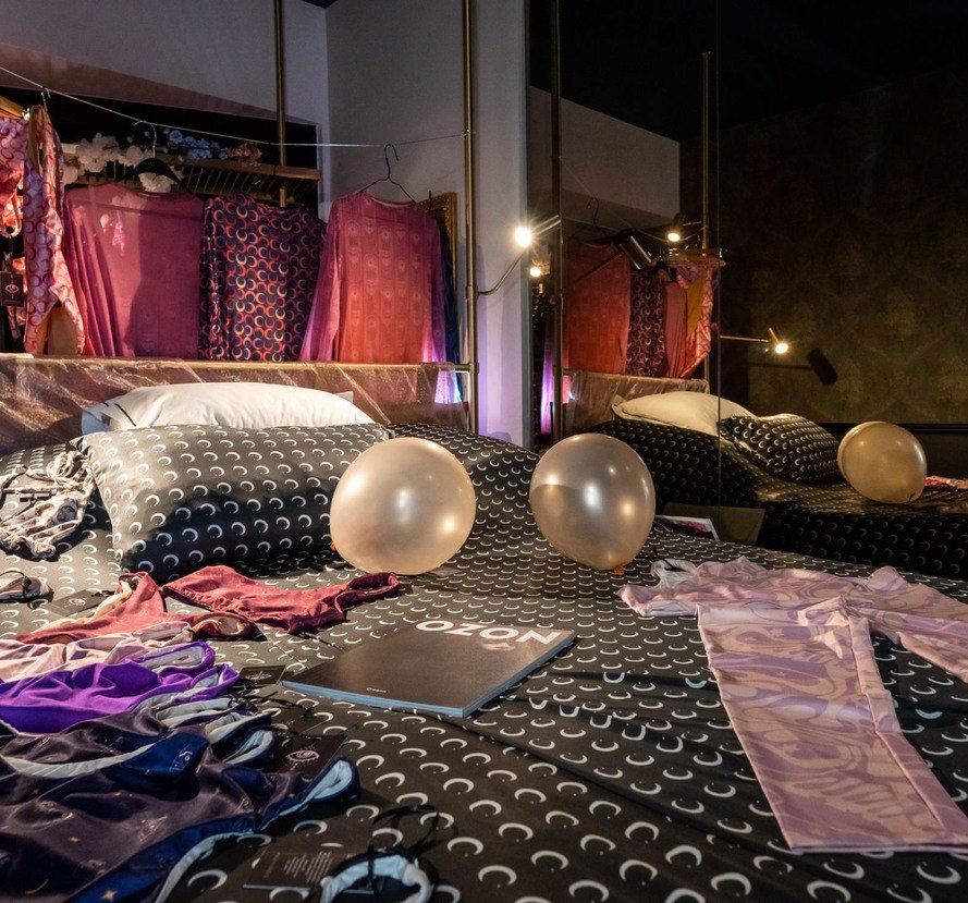 Hotel room styled with garments and an OZON magazine